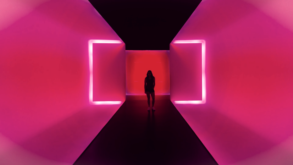 a person standing in a dark tunnel with bright lights